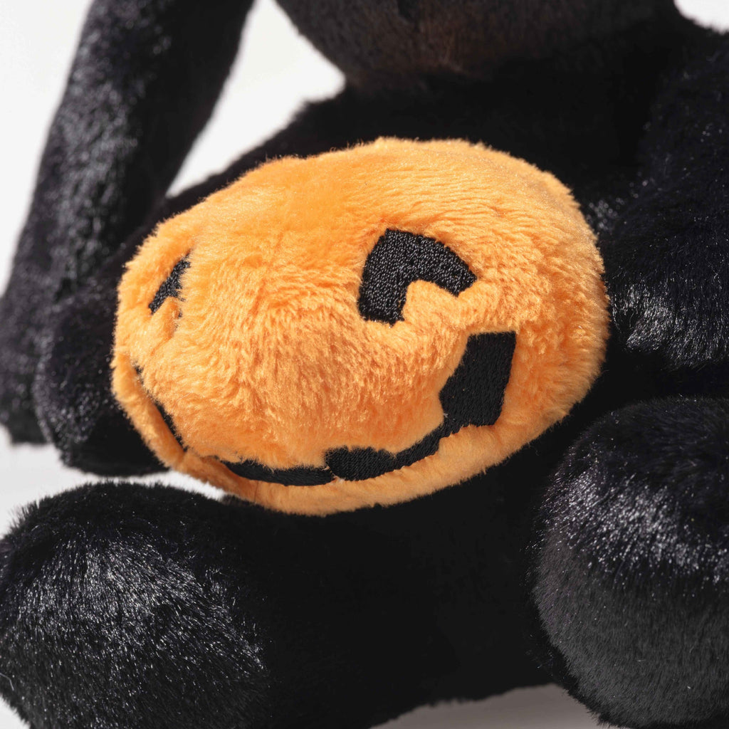 A close-up of the Steiff Mr. Spice Hoppie Rabbit holding an orange pumpkin plush with a black stitched jack-o’-lantern face.