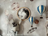 A whimsical wall decor featuring the "Hot Air Balloon - Marine Blue" plush, accompanied by a charming rabbit in a hat, blue and white wooden balloon ornaments, planets, and a moon illustration set against a starry background—perfect as handmade children's room decor.
