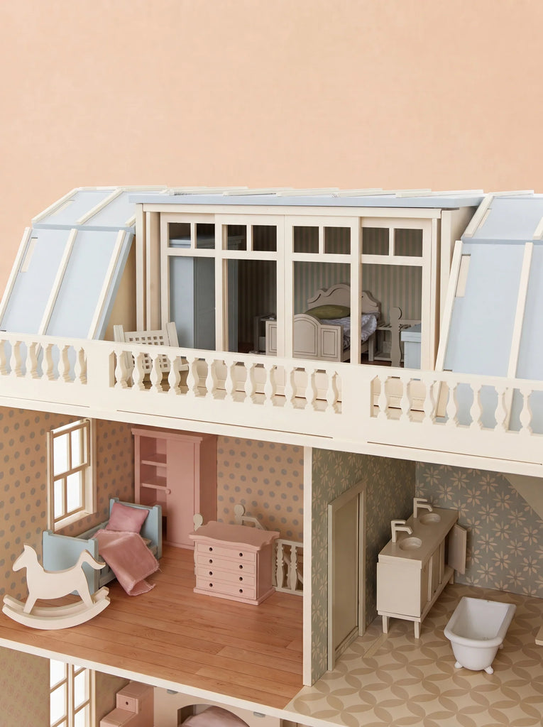 A detailed, fully furnished interior of the "Fully Furnished Dollhouse With Lights, House of New York - The Six-Storey Giant" showcases pastel-colored rooms with miniature furniture—including a rocking horse, beds, and a bathtub—all situated beneath a glass-roofed attic.