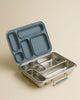 An open Haps Nordic - Stainless Steel Lunch Box - Multi-Compartment (Ocean) with a blue, sectioned lid showcases its multiple food storage compartments against a beige background. This bento lunch box is ideal for keeping your meals organized and fresh.