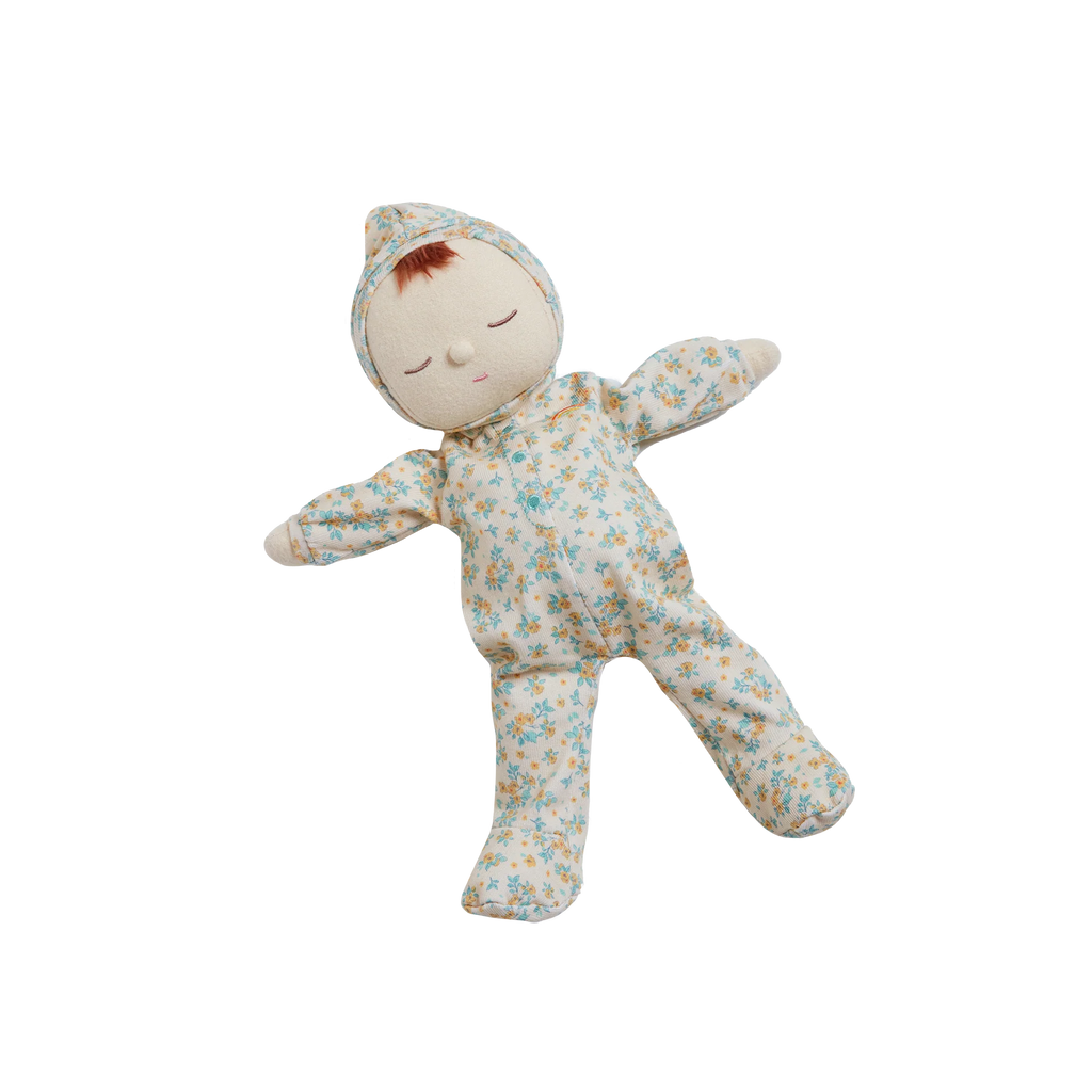 Olli Ella Dozy Dinkum - Pickle Blossom: A cloth doll with closed eyes, dressed in a blue and yellow floral-patterned onesie and matching cap, lying on a white background—part of the delightful Dozy Dinkum collection.