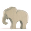 A small Ostheimer Small Elephant - Eating figurine with a textured light gray finish and intricate carved details, including a cutout silhouette and painted black eyes, suitable for imaginative play, against a white background.
