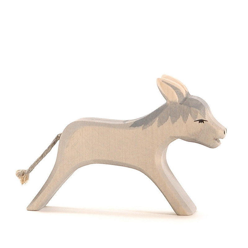 A handcrafted Ostheimer Donkey Running toy with a simple, smooth design featuring a light gray body, darker gray markings, upright ears, and a small tail made of string, standing against a white background.