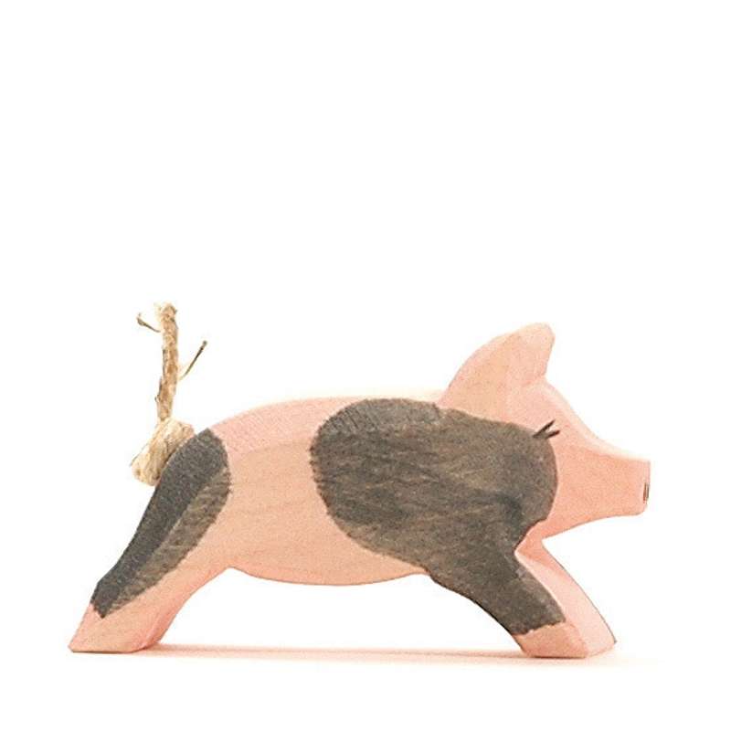 A handcrafted Ostheimer Spotted Piglet - Running figurine painted in shades of pink and gray, with a rustic twine loop on its back, against a white background.