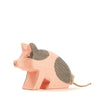 A handcrafted Ostheimer Spotted Piglet figurine painted in pink and gray with a curly tail, positioned facing right on a white background.
