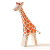 A handcrafted Ostheimer Giraffe - Running with a smiling face, orange spots, and a small tail, standing upright against a white background.