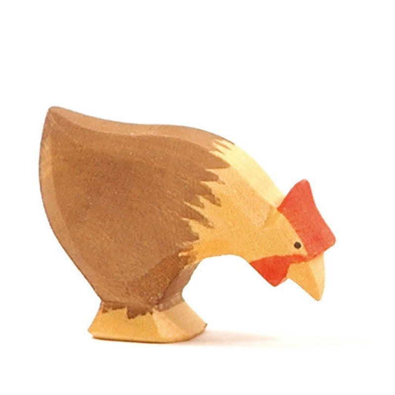 A small, handcrafted Ostheimer Hen Picking - Brown wooden figurine with a brown body, yellow beak, and red comb and wattle. Made from sustainably sourced materials, this toy depicts the chicken in a pecking position against a plain white background.