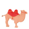 A handcrafted Ostheimer Camel With Saddle toy with a natural finish and bright red saddle, standing on a plain white background.