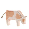A handcrafted Ostheimer Cow - Eating with a simplistic design, featuring soft white and light brown patches, and a small brown tail made of string, on a plain white background.