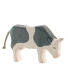 A handcrafted Ostheimer Cow - Black & White - Eating with a stylized design, featuring prominent gray patches and a simple black line for the eye, set against a plain white background.