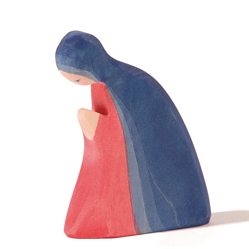A handcrafted Ostheimer Mary figurine painted in blue and red, depicted in a bowed, contemplative posture, isolated on a white background.