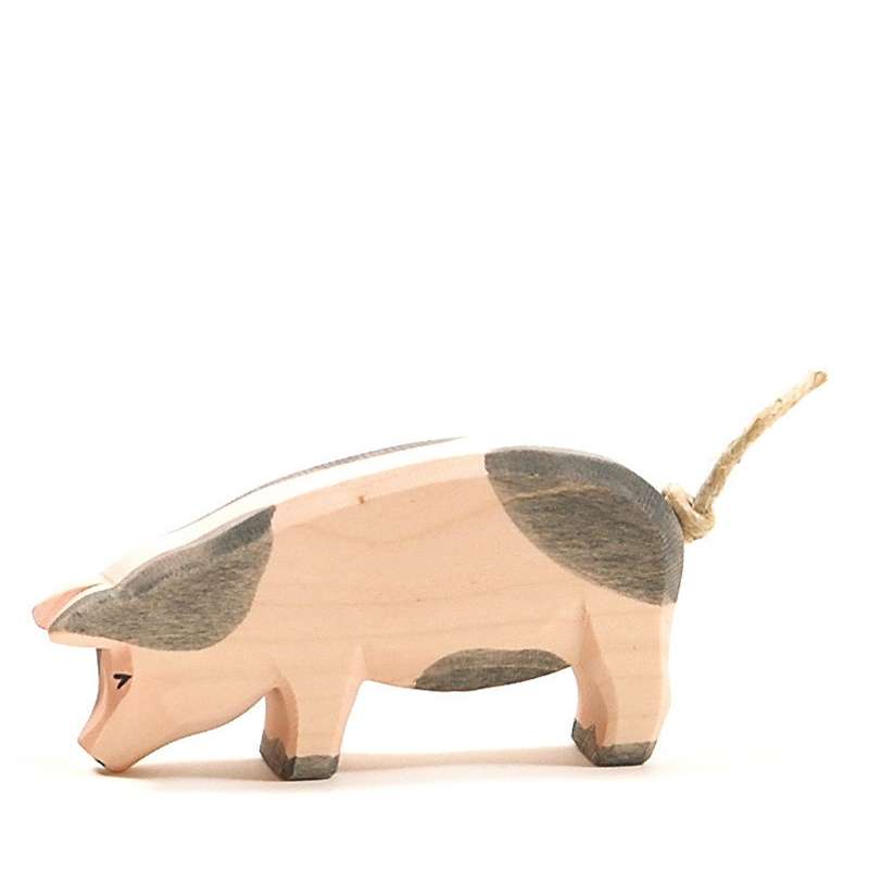 A handcrafted Ostheimer Spotted Pig - Head Low figurine with painted grey spots, featuring a twine tail, on a plain white background.