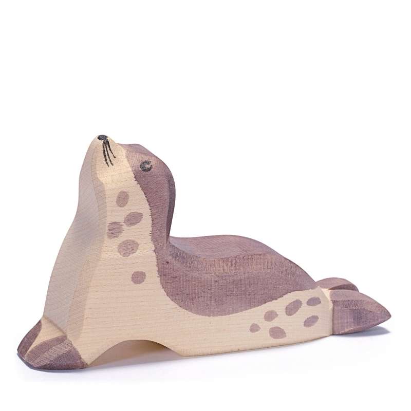 A handcrafted wooden Ostheimer Sea Lion - Head Up with a natural wood finish and painted features, such as spots and eyes, lying on a white background.