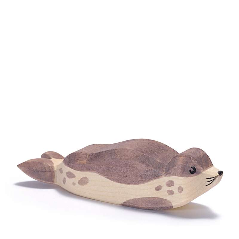 A handcrafted wooden toy Ostheimer Sea Lion - Resting with a smooth finish and painted details, featuring a smiling face and spotted body, isolated on a white background.