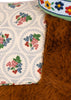 Close-up of a Konges Sloejd Fiona Horse cuddly toy with brown fur, a floral patterned saddle, and a green harness with embroidered flowers.