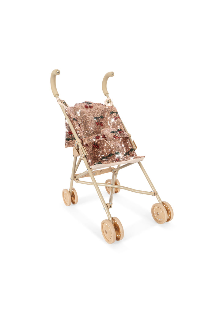 Konges Sloejd Sparkly Doll Stroller - Cherry Sequin with a sparkly pink, sequined seat featuring a cherry pattern, double wheels, and a light-colored frame.