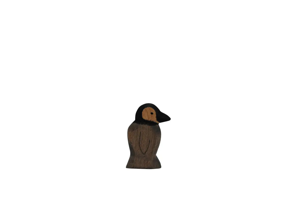 The Handmade Holzwald Penguin, Small, features a light brown face, dark beak, and dark brown body on a plain white background—ideal for sustainable wooden toy enthusiasts.