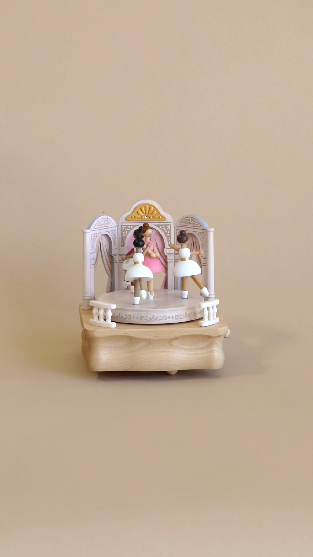 The wooden ballerina music box in motion with soft melody playing.