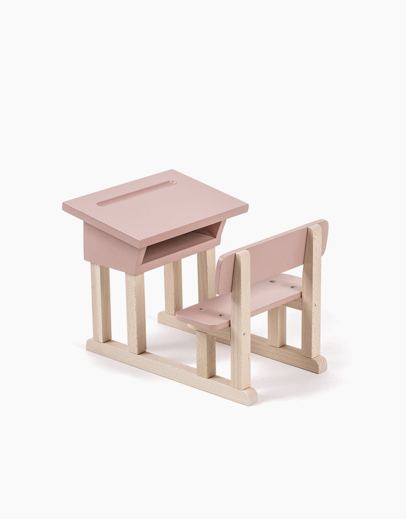 Introducing the Minikane Doll School Desk - Powder Pink: A handmade, small wooden toy desk with an attached bench seat, perfect for Minikane Babies. The desk and bench feature a light pink surface, with legs and a support structure crafted from natural wood. This minimalistic wooden school desk is ideal for a child or dollhouse.