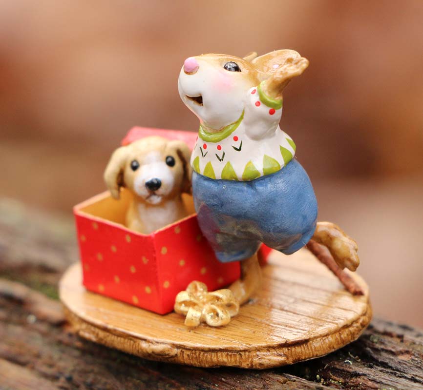 The Wee Forest Folk Tiny Collectible - Christmas Critter features a hand-sculpted mouse in festive attire beside a red gift box with a puppy, on a wooden base—an adorable addition to any miniature collection.