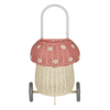 The Olli Ella Rattan Mushroom Luggy - Pink is a woodland-inspired, two-wheeled basket shaped like a mushroom, with a beige base, pink spotted cap, hand-woven rattan body, and a curved white handle on top.