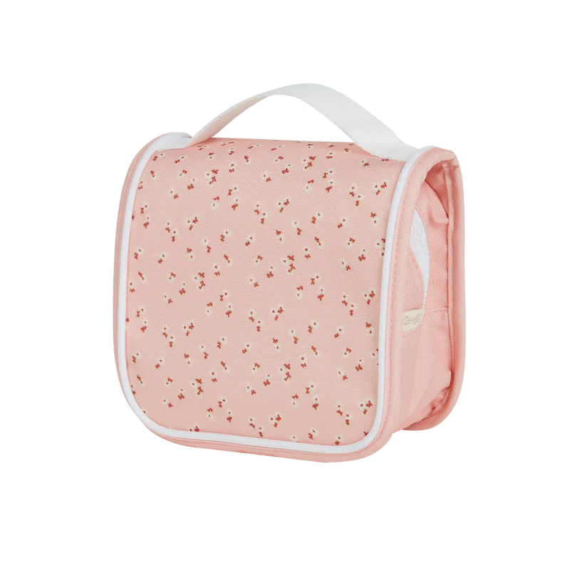 Image of a pink "Olli Ella See Ya Wash Bag - Pink Daisies" with a white handle and a subtle floral pattern, featuring small, scattered flowers. The bag is viewed from a side angle against a black background.