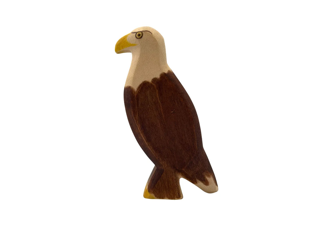 A Handmade Holzwald Eagle, painted in brown and white, standing upright on a plain white background. It's ideal for use as an educational toy.