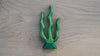 The Handmade Holzwald Seaweed is a green ceramic sculpture with three wavy, plant-like tendrils on a triangular base—an artful piece that could inspire the design of sustainable or educational toys.