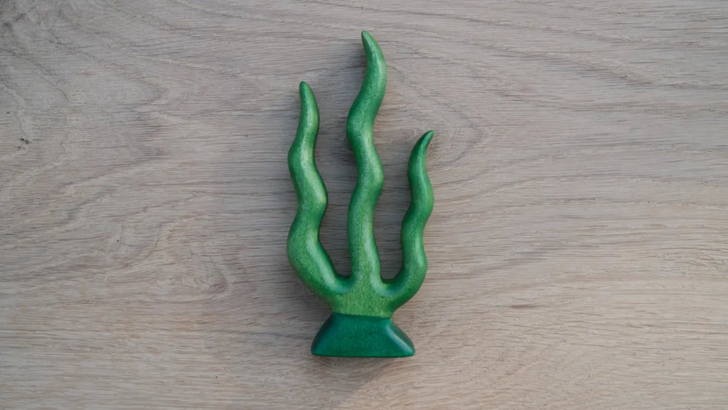 The Handmade Holzwald Seaweed is a green ceramic sculpture with three wavy, plant-like tendrils on a triangular base—an artful piece that could inspire the design of sustainable or educational toys.