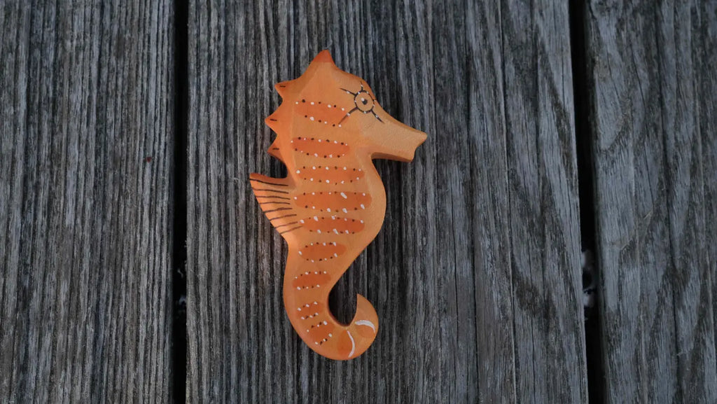 Handmade Holzwald Sea Horse ornament with painted stripes and details, representing a beautiful addition to any collection of sustainable toys.