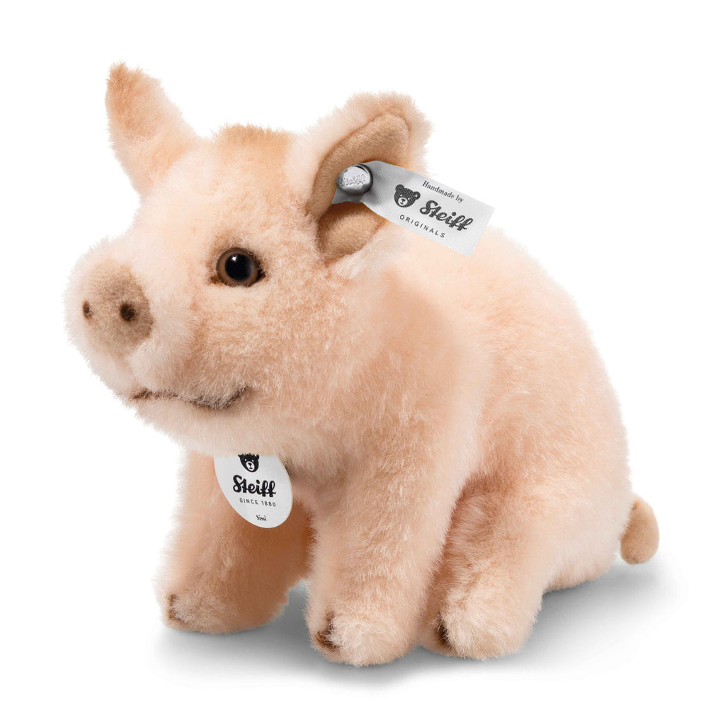 The Steiff Sissi Piglet is a soft, light pink plush toy with black eyes, a small snout, and Steiff tags on its ear and neck. Sitting upright and cuddly, it’s a beautifully crafted heirloom stuffed animal for generations.