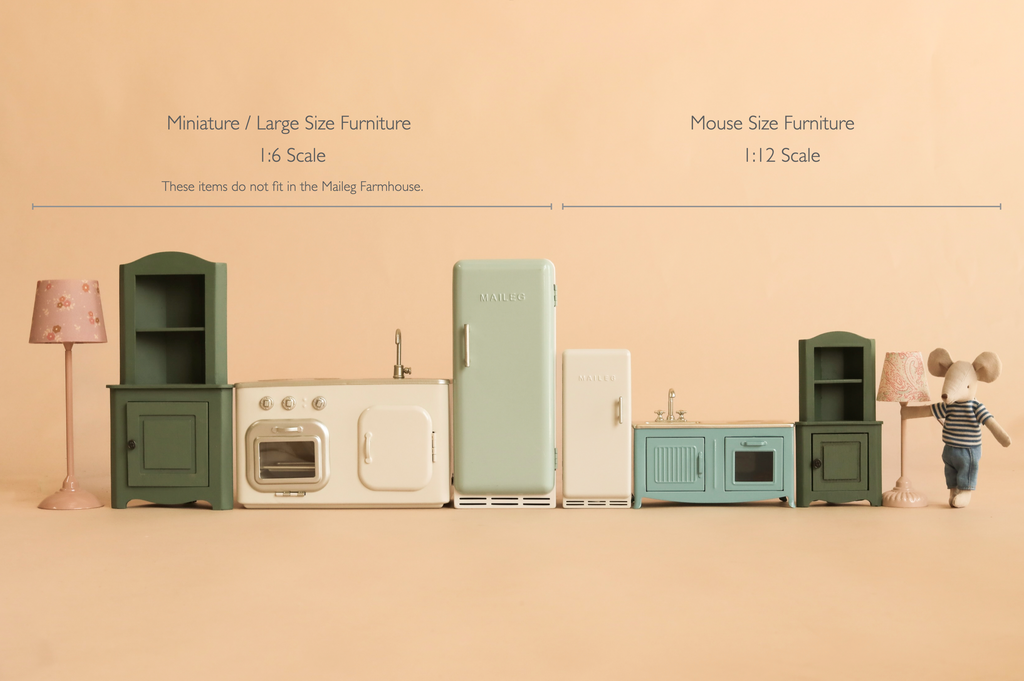 Two sets of miniature kitchen furniture in different scales (1:6 and 1:12) are displayed side by side, each clearly labeled with its size. A small toy mouse stands beside the smaller set on the right, next to a charming Maileg Metal Fridge, Mouse Size - Off White—perfect for any tiny kitchen scene or as a delightful fridge for Maileg mice.