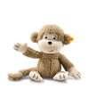 The Steiff Brownie Monkey is a plush toy with light brown textured fur, cream hands, feet, and face, black stitched features, a yellow tag on its left ear, and one arm raised—an adorable heirloom to cherish for years.