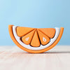 A creatively designed Wooden Tangerine Stacking Toy made from layers of white and orange materials, displayed on a light natural wood surface against a soft blue background.