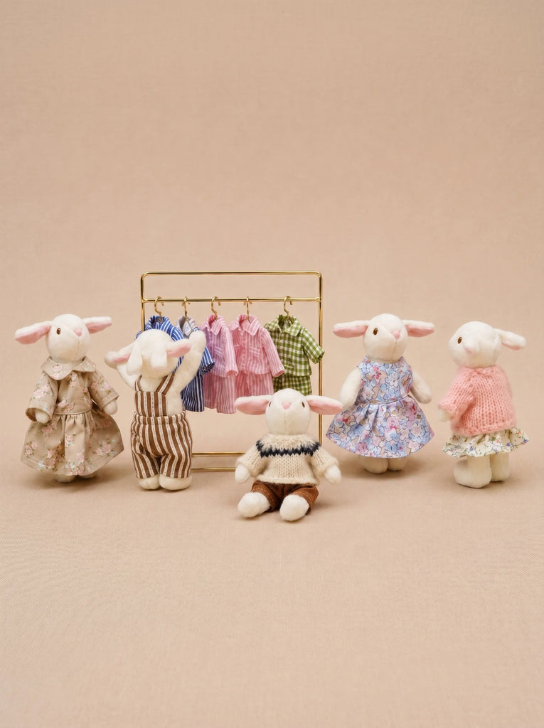 Five Little Forest Animals — The Bellevue Family, crafted from organic cotton dolls material and dressed in various outfits, stand and sit around a gold clothing rack adorned with miniature clothes, all set against a beige background.