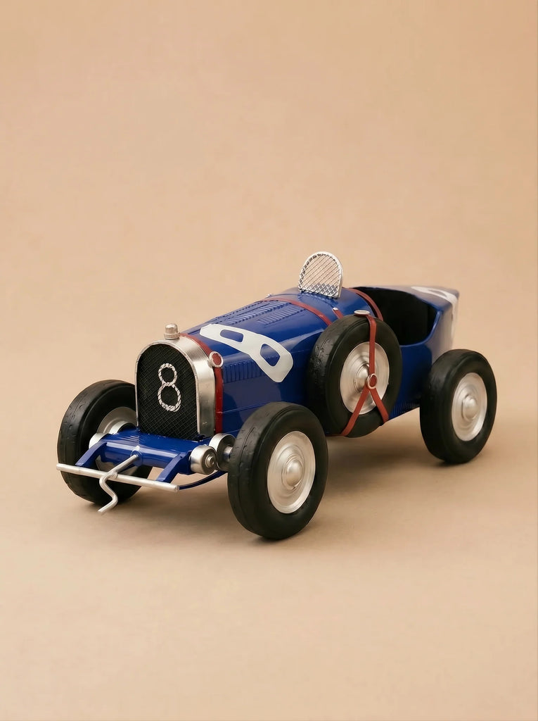 Introducing "Little Forest Animals — The Grand Prix": a blue vintage handcrafted die-cast car inspired by the iconic Bugatti Type 35, complete with large black tires, white rims, and the number eight on its grille—all beautifully set against a plain beige background.