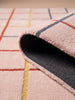 A close-up of the Little Forest Animals Silk Rug — The Palette showcases its vibrant design in light pink, accented with red, yellow, and blue grid lines. One corner is flipped to reveal a dark gray non-slip underside—perfect for adding comfort and safety to any designer kids room rug collection.