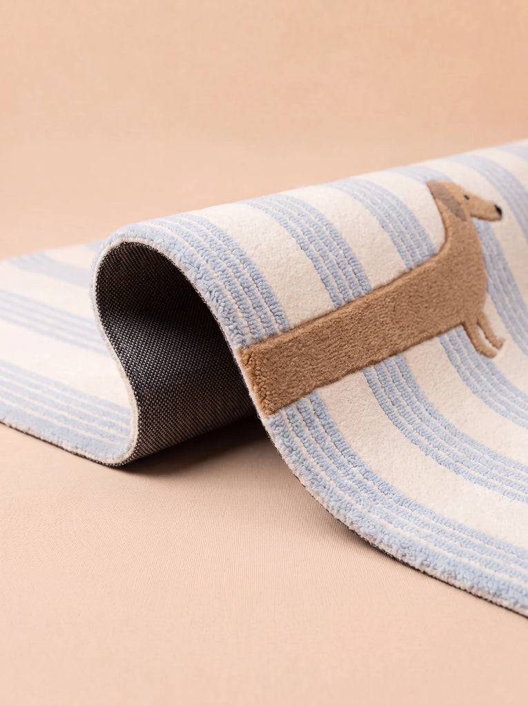 The Little Forest Animals Silk Rug — The Dachshund features playful blue and white stripes and a charming brown dachshund design, making it the perfect silk rug to add character and fun to any children’s room.