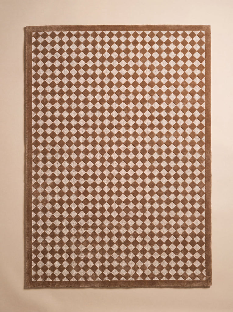 The Little Forest Animals Silk Rug — The Diamond is a rectangular hand-tufted rug featuring a repeating brown and white diamond checker pattern framed by a solid brown border, shown on a neutral background. This modern children's room rug skillfully combines contemporary style with plush comfort, making it an inviting spot for play and relaxation.