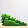 A green wooden toy painted with non-toxic paint, in the shape of a Wooden Large Shrub, standing on a light wooden surface against a soft white background.