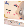 A Konges Sloejd Music Set Petite - Rainbow Twinkle wooden musical flute decorated with rainbow, star, and cherry decals, positioned in front of a patterned fabric bag with a tambourine edge.