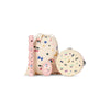 A Konges Sloejd Music Set Petite - Rainbow Twinkle consisting of a pink recorder, a pink egg shaker, and a tambourine arranged in front of a drawstring bag, all decorated with colorful rainbows, stars, moons, and cherry motifs.