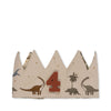 The Konges Sloejd Birthday Crown - Dino is a beige cotton crown with dinosaur illustrations, a palm tree, and a bold red number 4 at the center. Its adjustable fit and jagged, pointed top edge create a playful birthday look.