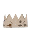 The Konges Sloejd Birthday Crown - Dino is a beige cotton crown with pointed tips, embroidered dinosaurs, palm trees, and stars. It’s adjustable with two central Velcro patches for easy fastening.