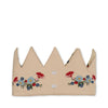 The Konges Sloejd Birthday Crown - Flower is a beige fabric crown with pointed tips, decorated with embroidered red, blue, and white flowers and green leaves along the base.
