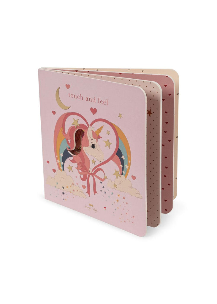 The Konges Sloejd Touch and Feel Book - Unicorn is a pink baby board book with a unicorn, rainbow, stars, and hearts on the cover. Inside, touch and feel pages feature polka dots and heart patterns for little ones to explore.