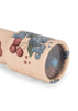A close-up of the Konges Sloejd Kaleidoscope - Cremona, an FSC-certified beige kaleidoscope featuring red cherry and blue grape illustrations, with a blue geometric pattern visible through the lens end.