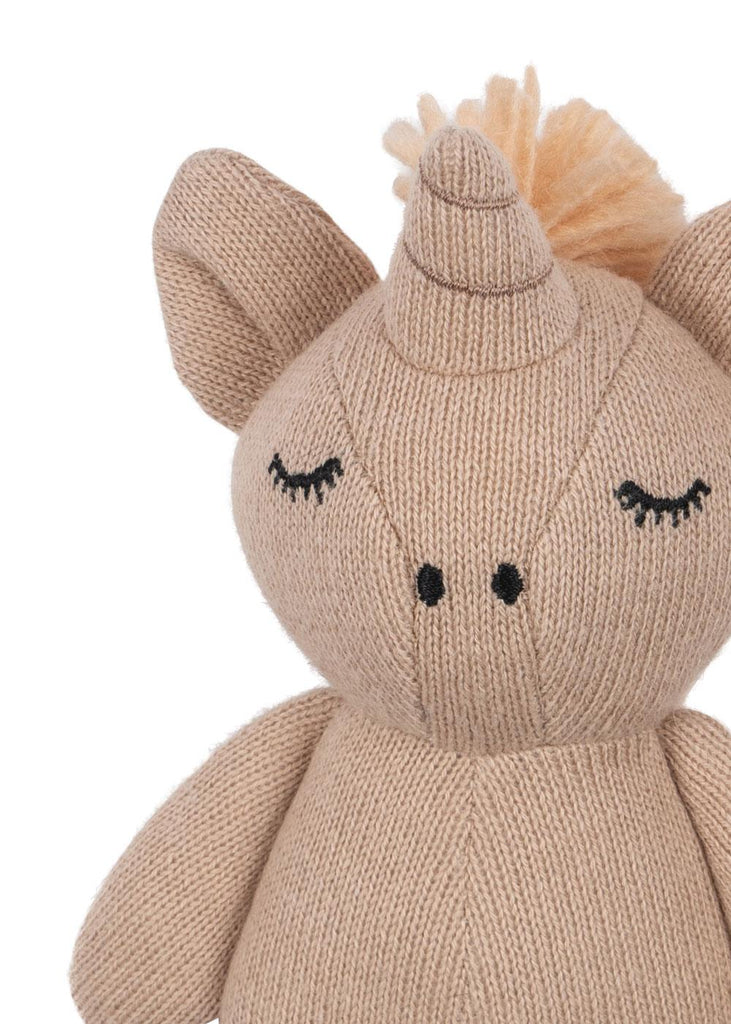 The Konges Sloejd Mini Unicorn Stuffed Animal is a beige, knitted organic cotton plush with closed embroidered eyes, large ears, a black stitched nose, and a yarn mane—an adorable sensory toy for babies.