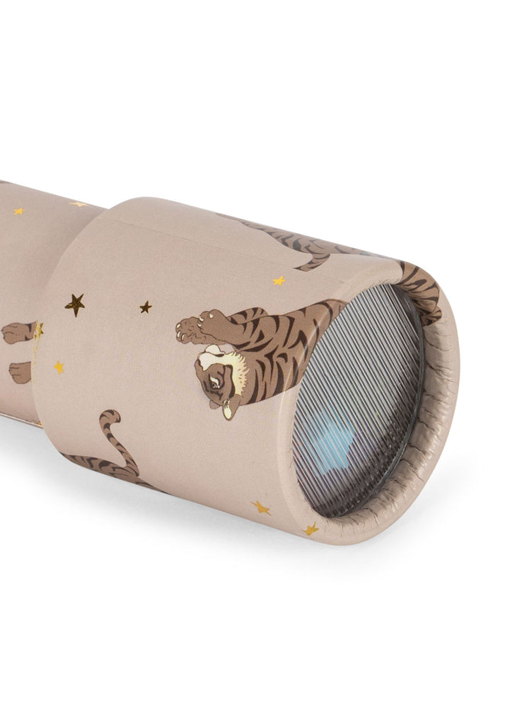 A close-up of the Konges Sloejd Kaleidoscope - Tiger, made from FSC-certified cardboard, features illustrated tigers and gold stars on beige, showing the lens, patterned tube, and glimpses of colorful pearls inside.