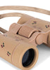 A close-up of Konges Sloejd Explorer Binoculars - Cherry, featuring a lightweight beige design with adjustable focus, a braided strap, small cherry illustrations, and cursive writing.